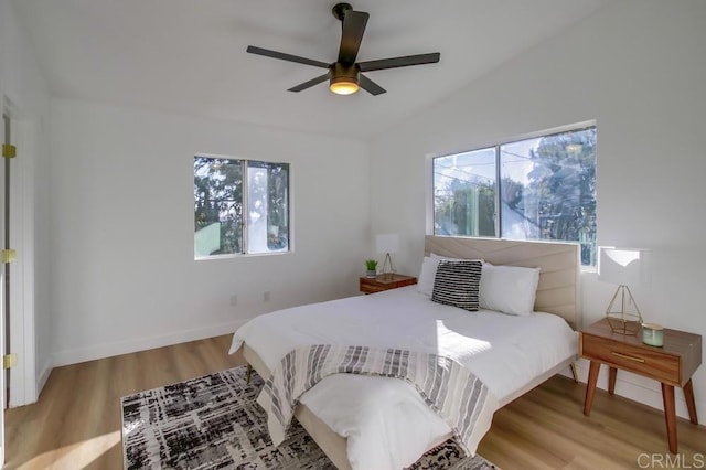 bedroom with ceiling fan, lofted ceiling, hardwood / wood-style floors, and multiple windows