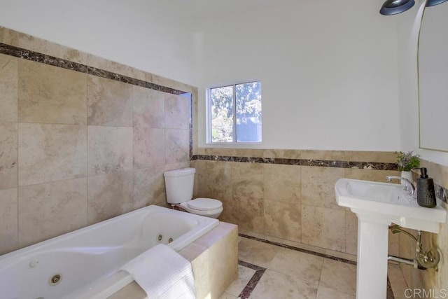 bathroom with toilet, tile walls, tile patterned floors, sink, and a relaxing tiled tub