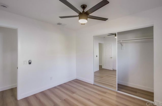 unfurnished bedroom featuring ceiling fan, a closet, and light wood-type flooring