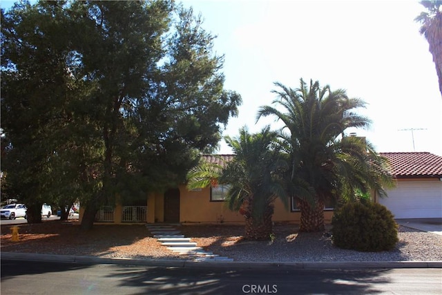 view of property hidden behind natural elements featuring a garage