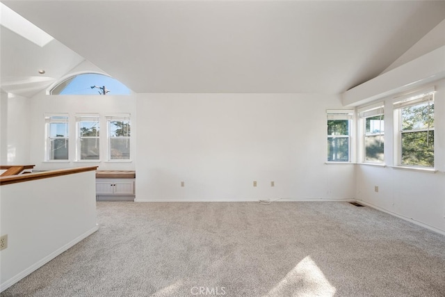 unfurnished room with vaulted ceiling and light colored carpet