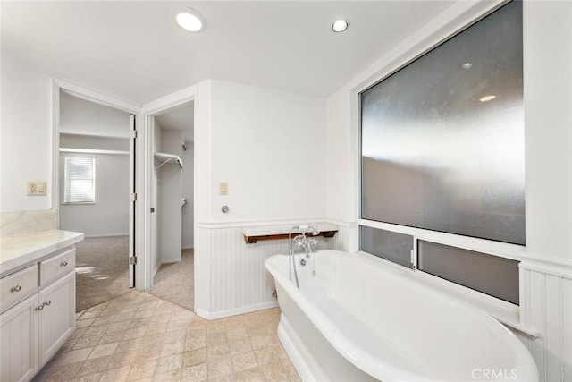 bathroom featuring a washtub and vanity