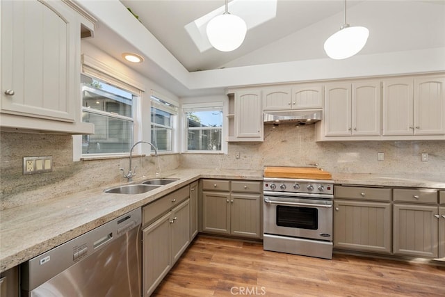 kitchen with sink, lofted ceiling, stainless steel appliances, and decorative light fixtures