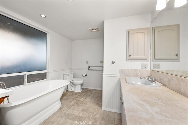 bathroom featuring toilet, vanity, and a bathing tub