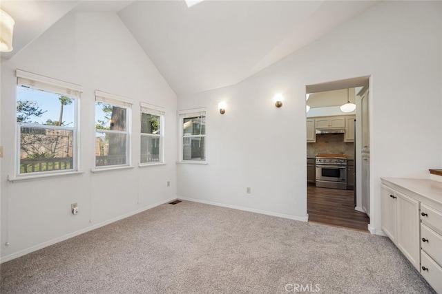 carpeted spare room featuring vaulted ceiling