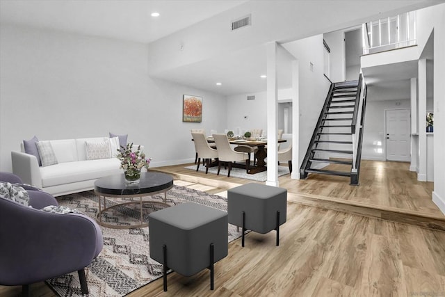 living room featuring a towering ceiling and hardwood / wood-style flooring