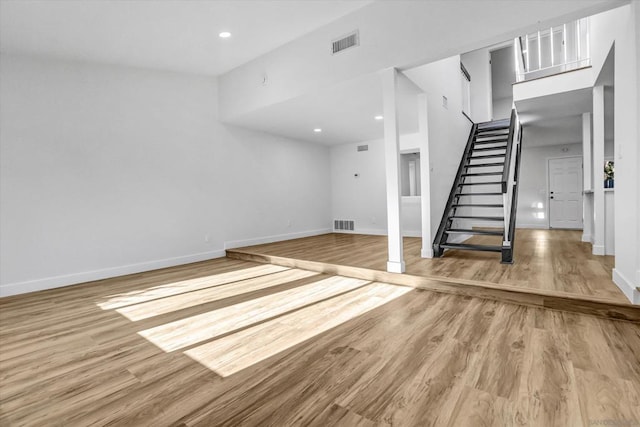 unfurnished living room with a high ceiling and hardwood / wood-style floors