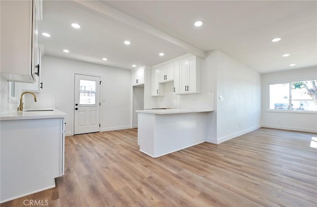 kitchen with sink, white cabinets, plenty of natural light, and light wood-type flooring