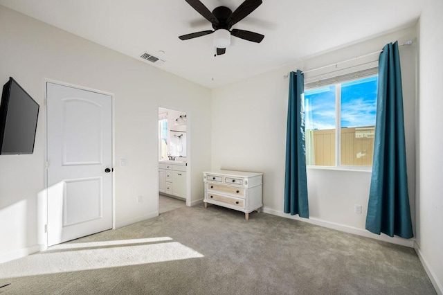 unfurnished bedroom with ceiling fan, light colored carpet, and ensuite bath