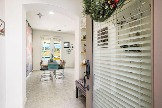 hall featuring light tile patterned floors and french doors