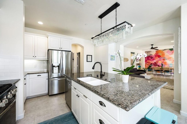 kitchen with stainless steel appliances, an island with sink, white cabinetry, and sink