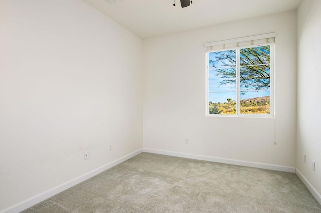 spare room featuring light carpet and ceiling fan