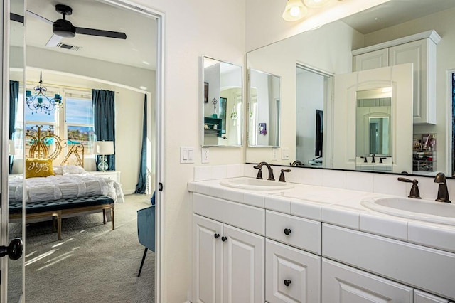 bathroom with vanity and ceiling fan with notable chandelier