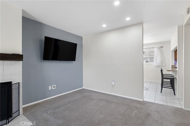 unfurnished living room featuring light carpet and a tile fireplace