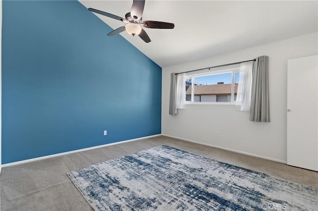 empty room with ceiling fan, carpet floors, and vaulted ceiling