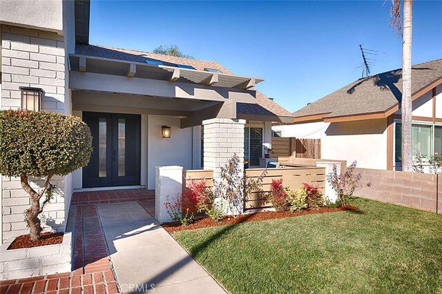 property entrance with french doors and a lawn