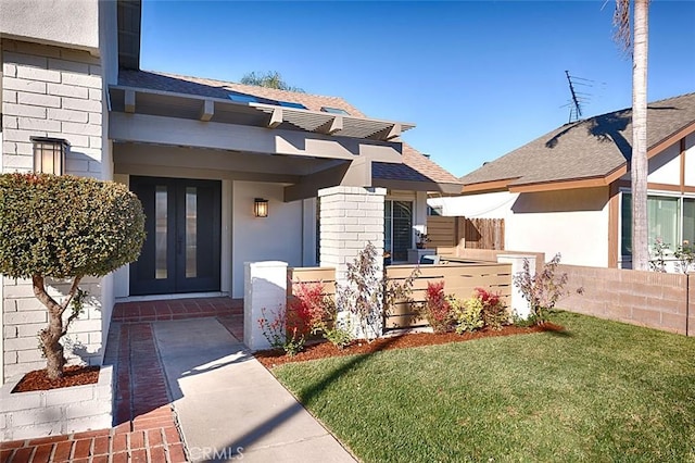 entrance to property featuring a yard and french doors