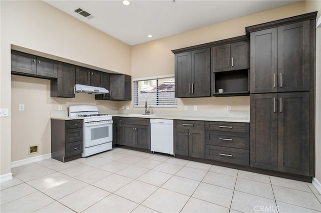 kitchen featuring sink, white appliances, dark brown cabinets, and light tile patterned flooring