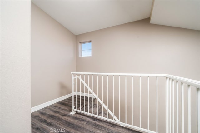 corridor with lofted ceiling and hardwood / wood-style floors