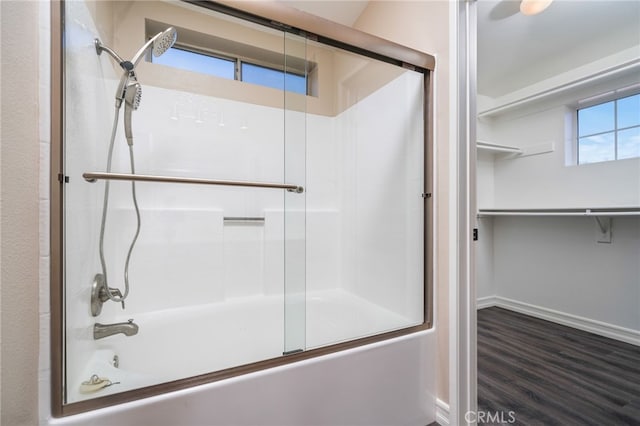 bathroom featuring hardwood / wood-style flooring and combined bath / shower with glass door