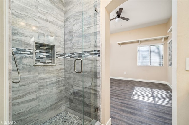 bathroom featuring wood-type flooring, ceiling fan, and a shower with shower door