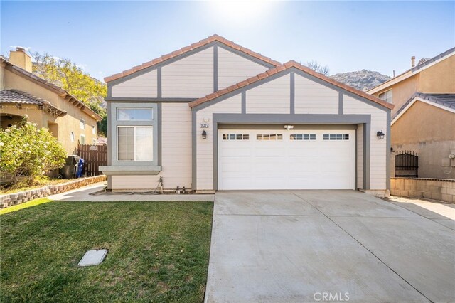 view of front of house with a mountain view, a front lawn, and a garage