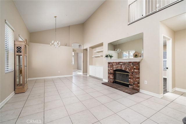 unfurnished living room with plenty of natural light, a chandelier, a brick fireplace, and light tile patterned floors