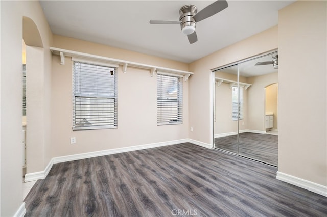 unfurnished bedroom with dark hardwood / wood-style floors, ceiling fan, and a closet