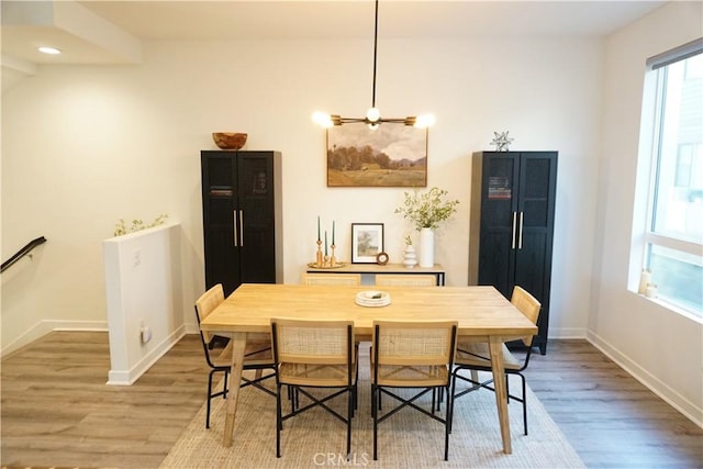 dining space featuring hardwood / wood-style flooring and a chandelier