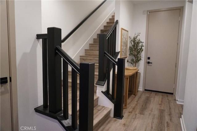 stairs featuring hardwood / wood-style floors