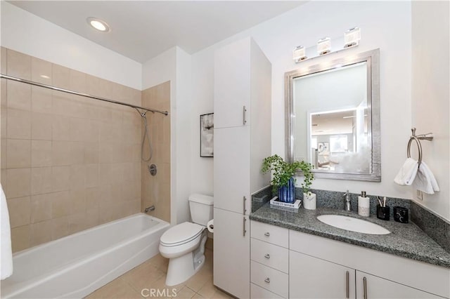 full bathroom featuring toilet, vanity, tiled shower / bath, and tile patterned flooring