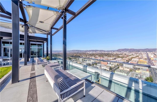 view of patio / terrace featuring a mountain view, a balcony, and ceiling fan