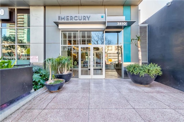 view of exterior entry with french doors and stucco siding