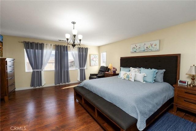 bedroom with dark hardwood / wood-style flooring and a notable chandelier