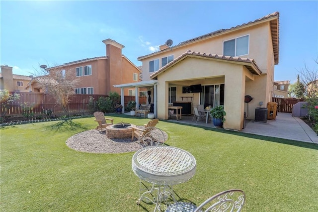 back of property featuring a lawn, an outdoor fire pit, a patio area, and central AC