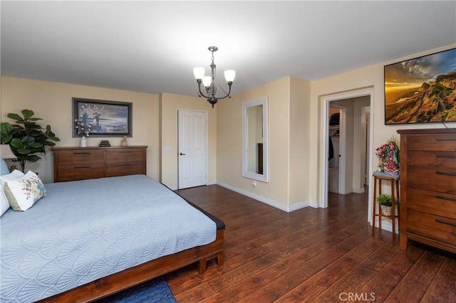 bedroom with a closet, dark wood-type flooring, and an inviting chandelier