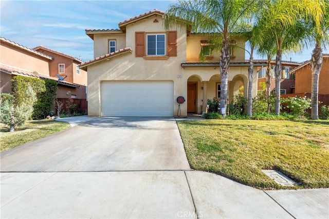 mediterranean / spanish home featuring a front lawn and a garage