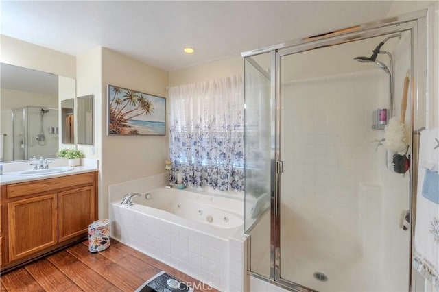 bathroom with vanity, independent shower and bath, and hardwood / wood-style floors