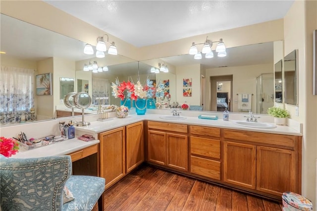 bathroom with vanity, wood-type flooring, and an inviting chandelier