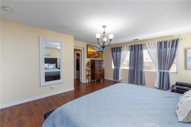 bedroom featuring a spacious closet, a chandelier, and hardwood / wood-style flooring