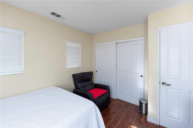 bedroom with dark hardwood / wood-style flooring and a closet