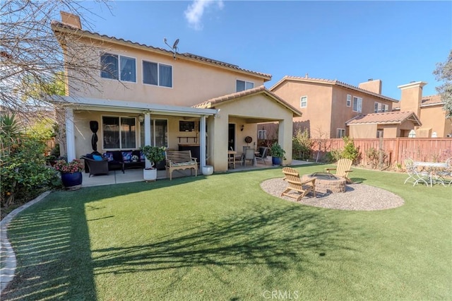 rear view of property featuring a patio area, an outdoor fire pit, and a lawn