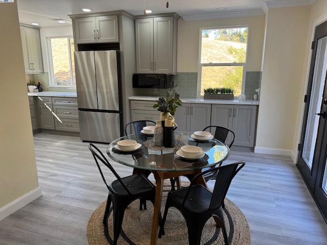 dining space featuring crown molding and light wood-type flooring