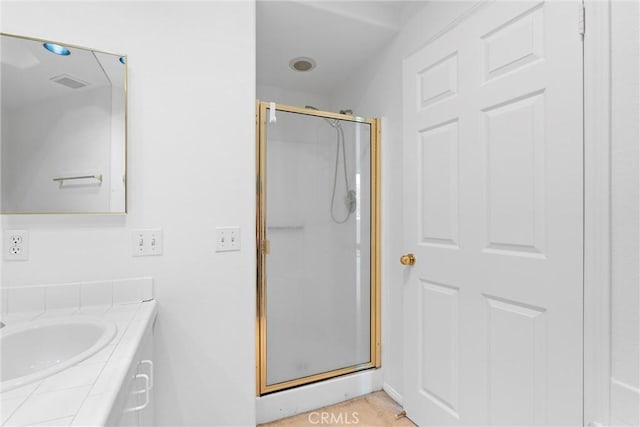 bathroom featuring vanity and a shower with shower door