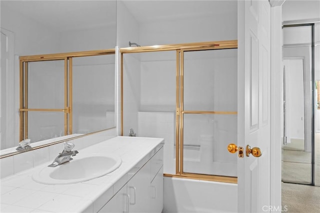 bathroom with vanity and combined bath / shower with glass door