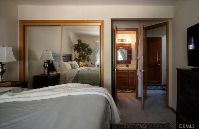 bedroom with connected bathroom, a closet, and carpet flooring