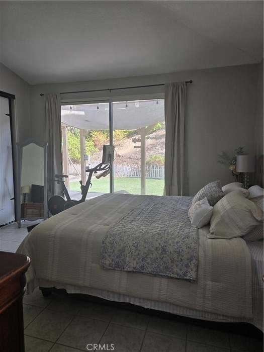 bedroom featuring access to outside, tile patterned flooring, and multiple windows