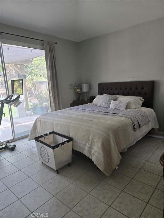 bedroom featuring access to exterior and light tile patterned floors