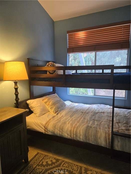 bedroom with vaulted ceiling and tile patterned flooring