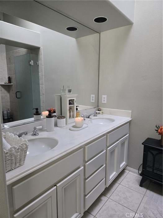 bathroom featuring tile patterned floors, vanity, and a shower with shower door